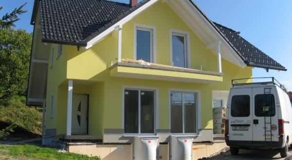 Rumena fasada novogradnje z belimi okenskimi obrobami